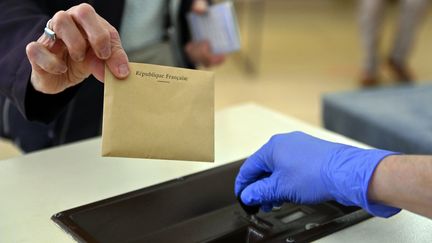 Une enveloppe près d'une urne. Photo d'illustration. (ALEXANDRE MARCHI / MAXPPP)