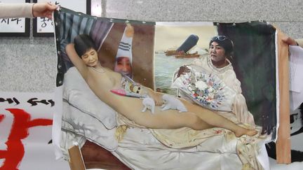 La toile de Lee Koo-Young représentant à la manière "d'Olympia" de Manet, la présidente sud-coréenne destituée, saccagée.
 (STR / YONHAP / AFP)