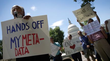 Un groupe manifeste son soutien &agrave; Edward Snowden, le 13 juin 2013 &agrave; Washington. Le jeune homme a r&eacute;v&eacute;l&eacute; un gigantesque programme de surveillance men&eacute;e par la NSA, l'agence de renseignements am&eacute;ricaine.&nbsp; (WIN MCNAMEE / GETTY IMAGES)