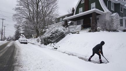 Une femme déneige l'allée devant sa maison, dans la région de Pittsburgh, aux Etats-Unis, le 17 janvier 2022. (STEVE MELLON / PITTSBURGH POST-GAZETTE / AP)