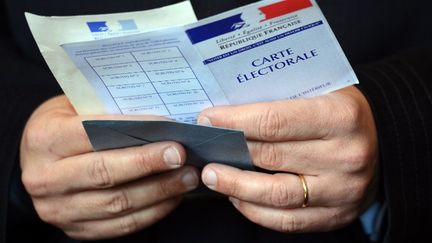 Un &eacute;lecteur tient son bulletin de vote ainsi que sa carte d'&eacute;lecteur, le 22 avril 2012, &agrave; Paris.&nbsp; (ERIC FEFERBERG / AFP)