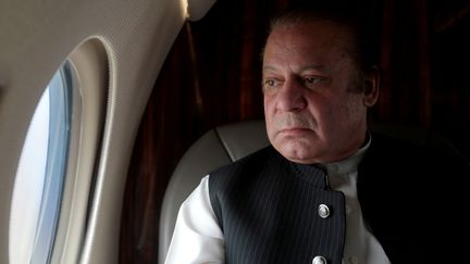 Nawaz Sharif regarde par la fenêtre de son avion, le 3 février 2017, à Karachi (Pakistan). (CAREN FIROUZ / REUTERS)