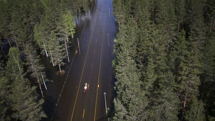 Deux hommes se d&eacute;placent en cano&euml; sur une route inond&eacute;e &agrave; Trysil (Norv&egrave;ge), le 26 mai 2014. (HEIKO JUNGE / NTB SCANPIX / AFP)