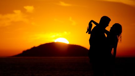 Un couple s'enlace avec un coucher de soleil à Rio au Brésil, le 13 février 2014. (CHRISTOPHE SIMON / AFP)