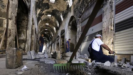 Des membres du Programme de développement des Nations unies (Pnud) nettoient le souk de Homs, le 14 août 2016
 (Louai Beshara / AFP)