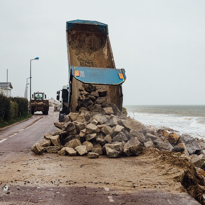 Un camion décharge des pierres pour renforcer la dune, le 11 mars 2020 à Gouville-sur-Mer (Manche). (PIERRE MOREL / FRANCEINFO)