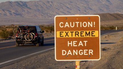 Un panneau prévient les automobilistes des dangers liées aux fortes chaleurs, dans la Vallée de la Mort, le 15 juillet 2023, en Californie (Etats-Unis). (DAVID MCNEW / GETTY IMAGES NORTH AMERICA / AFP)