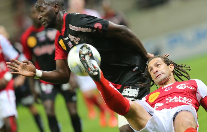 L'attaquant guingampais Mustapha Yatabar&eacute; &agrave; la lutte avec le d&eacute;fenseur r&eacute;mois Mickael Tacalfred, le 21 septembre 2013, &agrave; Reims.&nbsp; (FRANCOIS NASCIMBENI / AFP)