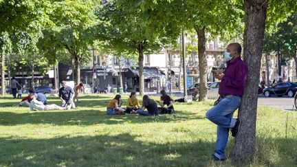 Des Parisiens sur la place Pereire, dans le 17e arrondissement de la capitale, le 18 mai 2020, en attendant la réouverture des parcs et jardins. (FRANCK RENOIR / HANS LUCAS / AFP)