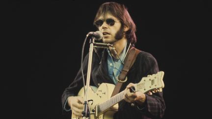 Le musicien canadien Neil Young en concert&nbsp;à Wembley (Londres, G-B) le 14 septembre 1974 en compagnie de Crosby, Stills et Nash. (MICHAEL PUTLAND / HULTON ARCHIVE / GETTY)