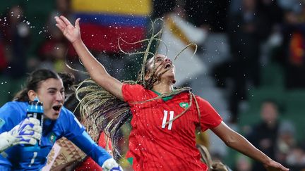 La gardienne du Maroc Khadija Er-Rmichi (à gauche) et la joueuse Fatima Tagnaout après leur qualification pour les huitièmes de finale contre la Colombie, le 3 août 2023. (COLIN MURTY / AFP)