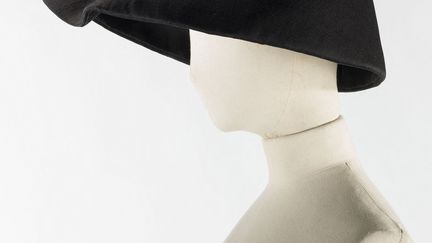 Pour Balenciaga plus que tout autre accessoire, les chapeaux jouent un rôle déterminant dans l’équilibre des volumes. Noirs, tout petits ou immenses, leurs formes résonnent dans le prolongement d’une silhouette d’encre ou comme contrepoint sombre à un modèle en couleur. Les toquets surmontés d’une plume ou ornés de broderies évoquent les coiffes des toréros tandis que la coleta, inspire au couturier, des volumes placés sur la nuque. Plus abstraits, de volumineux cônes tronqués, des envolées de velours ou des auréoles ébène, assurent l'harmonie de la ligne.
 (Collection Palais Galliera © Julien Vidal / Galliera / Roger-Viollet)