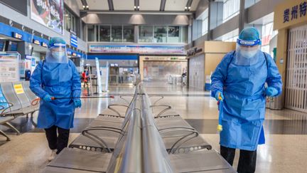 Des employés d'un aéroport de Bijie, dans la province de Guizhou, en Chine, désinfectent les sièges, le 10 octobre 2022. (AFP)