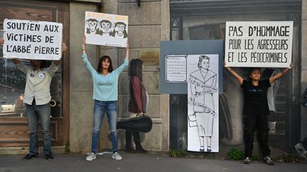 Des militants de l'association Mouv'Enfants collent une représentation de la résistante Lucie Aubrac sur la "Fresque des Lyonnais", en remplacement de celle de l'abbé Pierre, accusé de nombreuses violences sexuelles, lundi 21 octobre 2024, à Lyon. (HENRIQUE CAMPOS / HANS LUCAS / AFP)