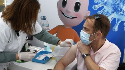 Une soignante vaccine un homme contre le Covid-19 à Tel-Aviv, le 3 janvier 2021. (JACK GUEZ / AFP)