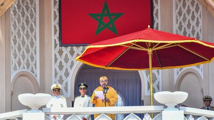 Le roi du Maroc Mohammed VI (C) prononçant un discours marquant le 20e anniversaire de son accession au trône, avec son frère le prince Moulay Rachid (R) et son fils le prince Moulay Hassan. (L) assis à ses côtés, dans la ville de Tétouan le 29 juillet 2019. (DRISS BEN MALEK / MOROCCAN ROYAL PALACE)