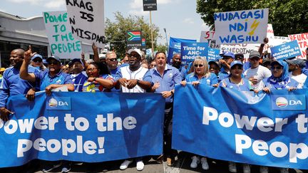 Le chef de l'Alliance démocratique (DA) John Steenhuisen (au centre) lors d'une manifestation contre la crise énergétique prolongée, à Johannesburg le 25 janvier 2023. (PHILL MAGAKOE / AFP)