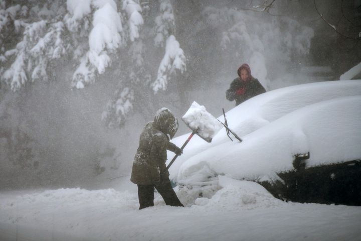 People try to clear snow around their car, in Stony Brook, New York, on January 29, 2022.   (ANDREW THEODORAKIS / GETTY IMAGES NORTH AMERICA / AFP)