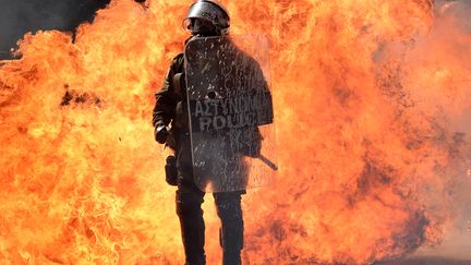 Un policier grec brave le feu lors d'&eacute;meutes &agrave; Ath&egrave;nes (Gr&egrave;ce), le 26 septembre 2012. (ARIS MESSINIS / AFP)