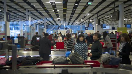 Des voyageurs attendent de passer les contrôles à l'aéroport de Roissy, le 31 décembre 2012. (FRED DUFOUR / AFP)