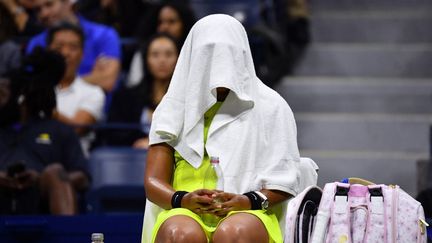 La tenniswoman japonaise Naomi Osaka, la tête cachée sous une serviette durant une rencontre de l'US Open, à New York (États-Unis), le 3 septembre 2021. (ED JONES / AFP)