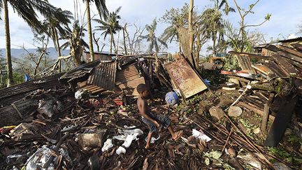 &nbsp; (Un enfant joue au ballon pendant que son père fouille les ruines de leur maison à Port-Vila, capitale du Vanuatu balayé par le cyclone Pam. © REUTERS/Dave Hunt/Pool)