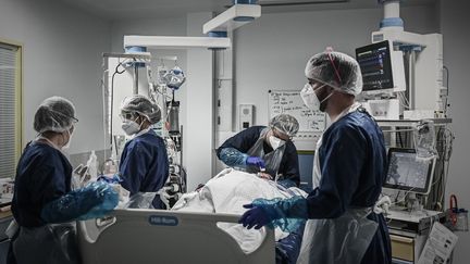 Des soignants autour d'un patient Covid-19, dans un service de réanimation de l'hôpital de Libourne (Gironde), le 6 novembre 2020. (PHILIPPE LOPEZ / AFP)