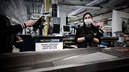 Une salariée avec un masque dans un supermarché. Photo d'illustration. (PHILIPPE LOPEZ / AFP)