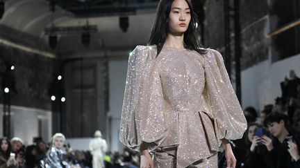 Pour la maison française Alexandre Vauthier, l'allure est sexy mais moins que d'habitude, un poil plus sage mais aussi plus portable, donc moins provoc. Sur une bande son, directement tirée des sixties, défile le vestiaire d'un parisienne chic qui ne dédaigne pas les codes classiques de la couture mais aime aussi être féminine, sensuelle et parfois coquine quand elle porte, par exemple, un petit short court avec une blouse blanche. 
 (STEPHANE DE SAKUTIN / AFP)