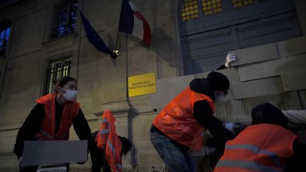 Des activistes réunis par le collectif Résistances locales érigent un mur symbolique devant le ministère de la Transition écologique, à Paris, le 26 avril 2022. (PIERRE-LOUIS CARON / FRANCEINFO)