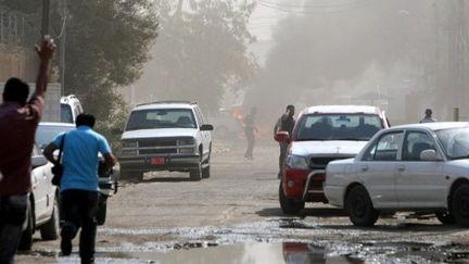 Des Irakiens se précipitent vers le lieu où un convoi de l'ambassade de France vient d'être attaqué le 20 juin 2011 (AFP - SABAH ARAR)