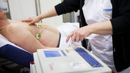 Une infirmi&egrave;re aupr&egrave;s d'un patient &agrave; l'h&ocirc;pital&nbsp;de la Croix Saint-Simon, &agrave; Paris, le 19 septembre 2013. (AMELIE-BENOIST / BSIP / AFP)