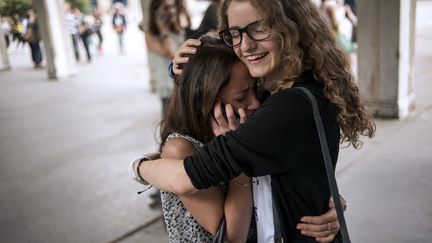 Deux lyc&eacute;ennes se congratulent lors de la publication des r&eacute;sultats du bac, le 4 juillet 2014, au lyc&eacute;e Claude-Monet, &agrave; Paris. (FRED DUFOUR / AFP)