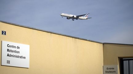 Un avion survole le centre de rétention du Mesnil-Amelot, en Seine-et-Marne. (JOEL SAGET / AFP)