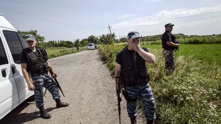 Des prorusses montent la garde &agrave; proximit&eacute; des lieux du crash du vol MH17 de la Malaysia Airlines dans l'est de l'Ukraine, le 25 juillet 2014. (BULENT KILIC / AFP)