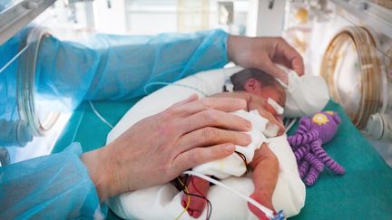 Un médecin s’occupe d’un bébé prématuré dans un incubateur du service néonatal du centre hospitalier d'Aix-en-Provence (Bouches-du-Rhône), le 6 octobre 2010. (CALMETTES / BSIP)