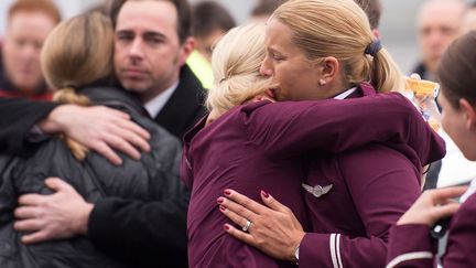 Des employ&eacute;s de la compagnie a&eacute;rienne allemande Germanwings s'enlacent apr&egrave;s une minute de silence &agrave; la m&eacute;moire des victimes du crash a&eacute;rien de l'A320 dans les Alpes fran&ccedil;aises, Cologne (Allemagne), le 25 mars 2015. (MARIUS BECKER / DPA / AFP)