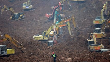 Le 23 décembre 2015, des pelleteuses s'affairent dans une zone industrielle de&nbsp;Shenzen (Chine).&nbsp;Trois jours plus tôt, une coulée de boue s'est déversée sur la ville détruisant une trentaine de bâtiments dans cette ville de 10 millions d'habitants. Quatre-vingt dix personnes sont portées disparues, les recherches se poursuivent. (KIM KYUNG HOON / REUTERS)