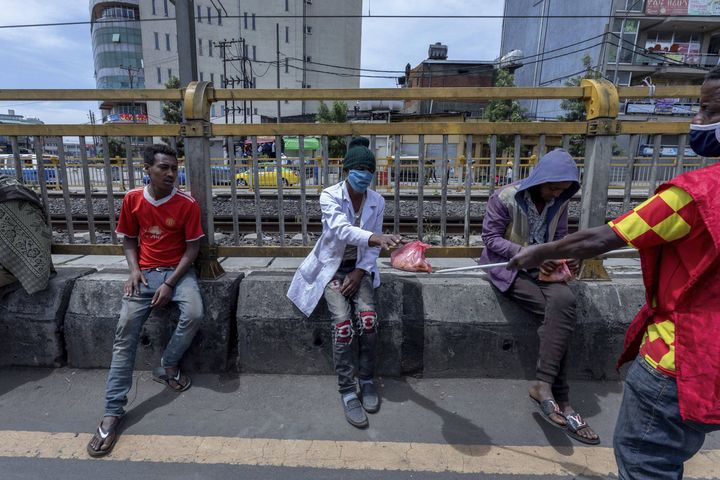 Distribution de repas à des sans-abri à Addis Abeba le 19 avril 2020. Les volontaires utilisent une perche métallique pour leur tendre la nourriture et&nbsp;éviter ainsi le risque de répandre le coronavirus. (MULUGETA AYENE/AP/SIPA / SIPA)