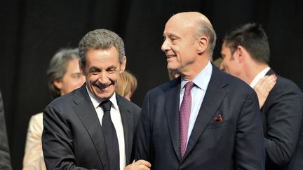 Nicolas Sarkozy et Alain Juppé lors d'un meeting des Républicains à Limoges (Haute-Vienne), le 14 octobre 2015. (NICOLAS TUCAT / AFP)