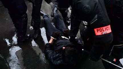 Un manifestant est interpellé par des policiers lors de la manifestation contre la proposition de loi "Sécurité globale", à Paris, le 12 décembre 2020. (MARTIN BUREAU / AFP)