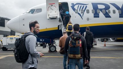 Des voyageurs montent dans leur avion pour le Royaume-Uni, depuis Nantes, en France, le 1er juillet 2020. (JULIEN MARSAULT / HANS LUCAS / AFp)