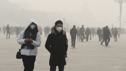 Les habitants de Pékin&nbsp;tentent de se prémunir contre la pollution avec des masques.&nbsp;Mercredi 21 décembre,&nbsp;le&nbsp;niveau de concentration aux particules-fines s'élevaient encore à 360 microgrammes par mètre cube. Le seuil d'alerte est, lui, fixé à 200. (JUN YASUKAWA / YOMIURI)