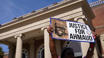 Une pancarte est brandie devant le tribunal de Glynn County, à Brunswick (Etats-Unis), le 18 octobre 2021. (SEAN RAYFORD / GETTY IMAGES NORTH AMERICA / AFP)