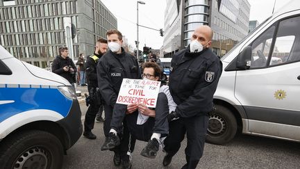 Des membres de Scientist Rebellion&nbsp;interpellés lors d'un sit-in visant à dénoncer la politique environnementale du gouvernement allemand, le 6 avril 2022 à Berlin (Allemagne).&nbsp; (ABDULHAMID HOSBAS / ANADOLU AGENCY / AFP)