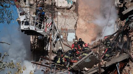 Les secouristes&nbsp;au milieu des débris d'un immeuble résidentiel touché par une frappe russe à Kiev (Ukraine), le 17 octobre 2022.&nbsp; (ANTONI LALLICAN / HANS LUCAS / AFP)