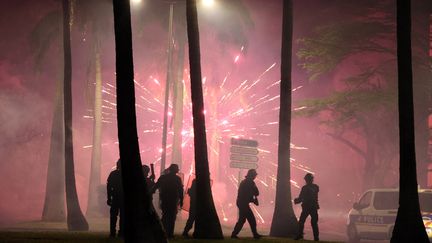 Des policiers visés par des engins pyrotechniques au Port, sur l'île de la Réunion, le 30 juin 2023. (RICHARD BOUHET / AFP)