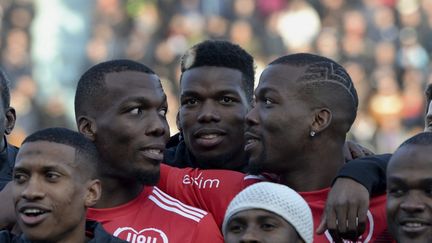 Le footballeur Paul Pogba (au centre) avec ses frères Florient Pogba (à gauche) et Mathias Pogba (à droite), réunis lors d'un match de gala en 2019. (GUILLAUME SOUVANT / AFP)