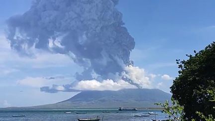 Des habitants regardent le&nbsp;volcan Lewotolo, entré en éruption en Indonésie, le 29 novembre 2020. (JOY CHRISTIAN / AFP)