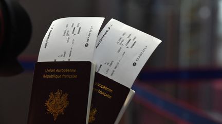 Des billets d'avion avec des passeports. (ERIC PIERMONT / AFP)